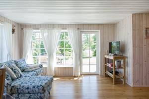 ein Wohnzimmer mit einem Sofa und einem TV in der Unterkunft Nordic Bliss beach house - Käsmu in Käsmu