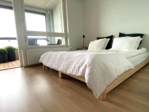 Goldfinger yksiö merinäköalalla 7 krs في هلسنكي: غرفة نوم بسرير كبير مع شراشف بيضاء ونافذة