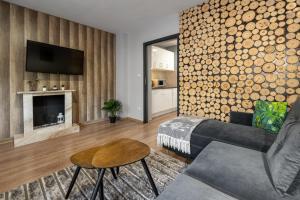 a living room with a couch and a fireplace at RentPlanet - Apartament Antałówka in Zakopane