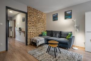 a living room with a couch and a wall of logs at RentPlanet - Apartament Antałówka in Zakopane