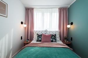 1 dormitorio con cama con almohada rosa y ventana en Apartament Diamond - darmowy Parking, ścisłe centrum - by Kairos Apartments, en Gliwice