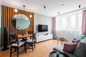 sala de estar con mesa y sofá en Apartament Diamond - darmowy Parking, ścisłe centrum - by Kairos Apartments, en Gliwice