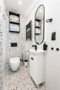 y baño con aseo, lavabo y espejo. en Apartament Diamond - darmowy Parking, ścisłe centrum - by Kairos Apartments, en Gliwice