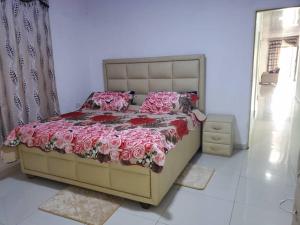- une chambre dotée d'un grand lit avec des draps et des oreillers roses dans l'établissement Savagem Furnished Apartment, à Freetown