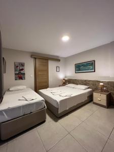 duas camas num quarto com duas mesas em Bayram Hotel em Cesme