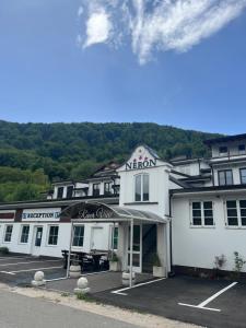 a large white building with a sign on it at Rooms and Apartments Neron Bihać in Lohovo