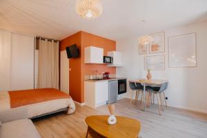 a bedroom with a bed and a kitchen with a table at L'ATELIER - Coeur de ville - Tout équipé in Cholet