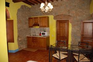 a kitchen with wooden cabinets and a table with chairs at La Mulattiera in Scarlino