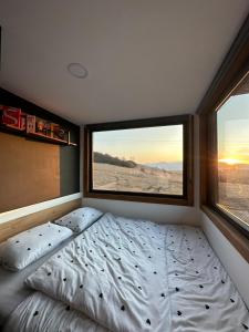 Ce lit se trouve dans un dortoir doté de 2 grandes fenêtres. dans l'établissement Na_ture, à Hrabušice