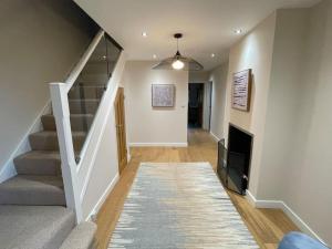 a hallway with a staircase with a tv and a stair case at Modern and cosy 4 bedroom home in the Mendip Hills, North Somerset in Axbridge