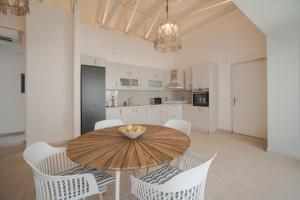 a kitchen and dining room with a wooden table and chairs at Kavo Seaside Luxury Apartment in Argasi