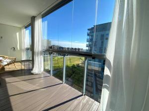 einen Balkon mit einer Terrasse mit Blick auf ein Gebäude in der Unterkunft Tilava yksiö 35,5 m2 merenrannalla in Helsinki