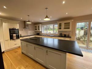 a large kitchen with a large black counter top at Modern and cosy 4 bedroom home in the Mendip Hills, North Somerset in Axbridge
