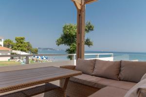un patio con sofá, mesa y el océano en Kavo Seaside Luxury Apartment en Argasi