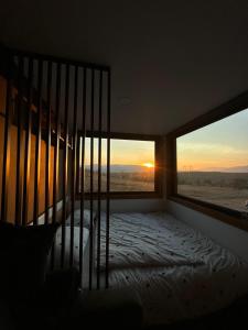 - une chambre avec un lit et une fenêtre donnant sur le coucher du soleil dans l'établissement Na_ture, à Hrabušice