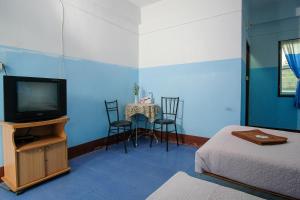 a room with a tv and a table with chairs at Blue House Pai in Pai