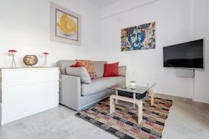 ein Wohnzimmer mit einem Sofa und einem TV in der Unterkunft Sea promenade apartment in Marbella M27 in Marbella