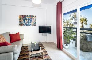 ein Wohnzimmer mit einem Sofa und einem TV in der Unterkunft Sea promenade apartment in Marbella M27 in Marbella