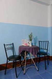 uma mesa com duas cadeiras e uma mesa com um vaso sobre ela em Blue House Pai em Pai