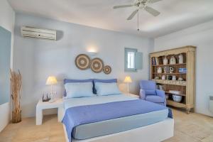 1 dormitorio con 1 cama azul y 1 silla azul en Villa Afroditi, en Antíparos