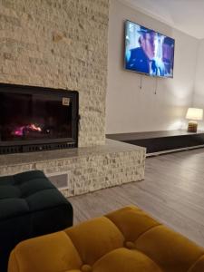 sala de estar con chimenea y TV de pantalla plana en Casa Eridav en Arcani