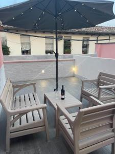 une terrasse avec 2 chaises et une table avec un parasol dans l'établissement Il Paradiso Holiday, à Ravenne