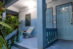 uma porta azul de uma casa com um banco e plantas em Blue House Pai em Pai