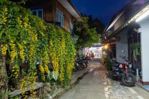 a group of motorcycles parked next to a wall with flowers at Blue House Pai in Pai