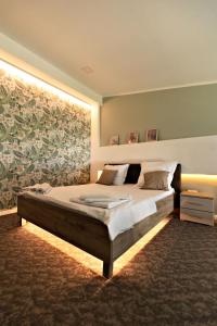 a bedroom with a large bed with a large painting on the wall at VIVO Loft Short Stay in Baia Mare