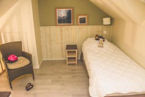 um quarto com uma cama com um urso de peluche deitado sobre ele em Résidence Goélia La Pommeraie em Branville