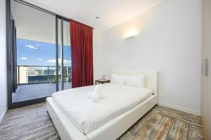 a bedroom with a white bed and a large window at Stunning New 2 Bedrooms Apt Shopping & Parking in Sydney