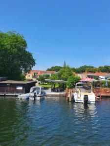 two boats are docked at a dock in the water at Ferienwohnungen Wassergrundstück Malchow in Malchow