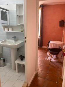 een badkamer met een wastafel, een tafel en een stoel bij Ida Chambres d'hôtes B&B in Montpellier