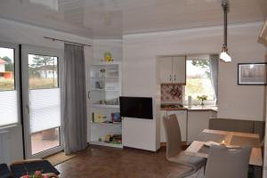 a living room with a dining table and a kitchen at Utlande-18 in Brösum