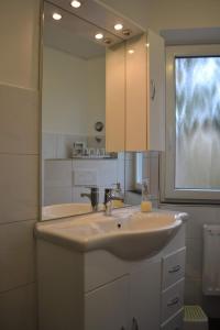 a bathroom with a sink and a large mirror at Utlande-18 in Brösum