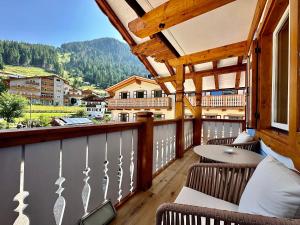 a balcony with chairs and a view of a mountain at Cesa Planber Apartments Mountain View SKI-IN SKI-OUT in Canazei