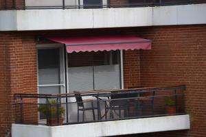 a balcony with a table and chairs on a building at Utlande-18 in Brösum