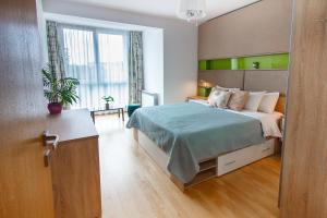 a bedroom with a bed with a green headboard at Gold Class Apartments AMS in Cluj-Napoca