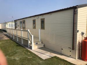 a building with a porch and stairs on it at Captivating 3-Bed Caravan at Golden Palm Skegness in Skegness