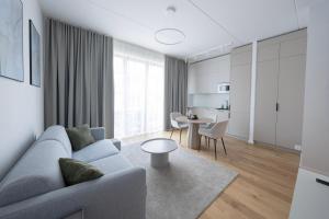 ein Wohnzimmer mit einem grauen Sofa und einem Tisch in der Unterkunft Bob W Pärnu in Pärnu