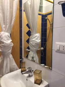 W łazience znajduje się umywalka i lustro. w obiekcie Aurelia in Blu w Rzymie