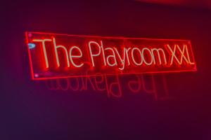 a red neon sign that reads the playroom wrote out at Playroom XXL Loft LOVE Room avec Espace spa Terrasse vue sur les toits Salle de jeux pour adultes Libourne centre 10 min de St Emilion Proche Bordeaux in Libourne