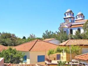 a large building with a clock tower in the background at Toula's Garden-View Apartment 3 in Moúdhros