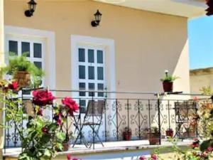 a balcony of a house with flowers on it at Toula's Garden-View Apartment 3 in Moúdhros