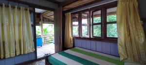 a room with a bed in a room with windows at O'hamok family in Battambang