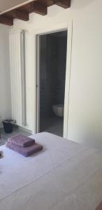 Un dormitorio con una cama con toallas moradas. en Agriturismo Cascina Lert, en Marone