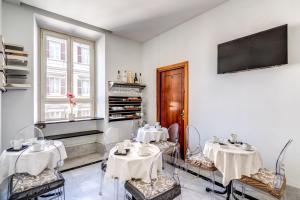 a dining room with two tables and a flat screen tv at Hotel Max in Rome