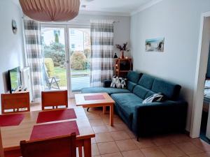 ein Wohnzimmer mit einem blauen Sofa und einem Tisch in der Unterkunft Appartmenthaus Ostseestrand in Kühlungsborn