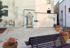 a bench sitting in front of a building with flowers at Sogni a Sud - The Fab Stay in Mesagne