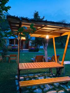 een houten picknicktafel met een paviljoen in een tuin bij Household Nikolic - Andrijevica, Montenegro in Andrijevica